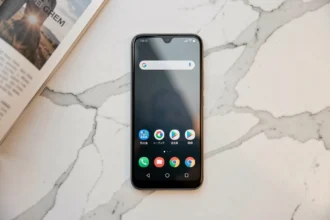Xiaomi 14T posé sur une surface en marbre blanc avec un magazine technologique ouvert, vue de dessus