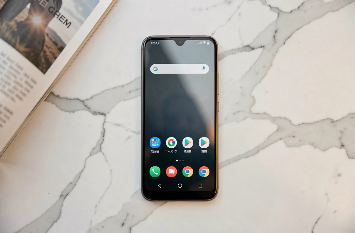 Xiaomi 14T posé sur une surface en marbre blanc avec un magazine technologique ouvert, vue de dessus